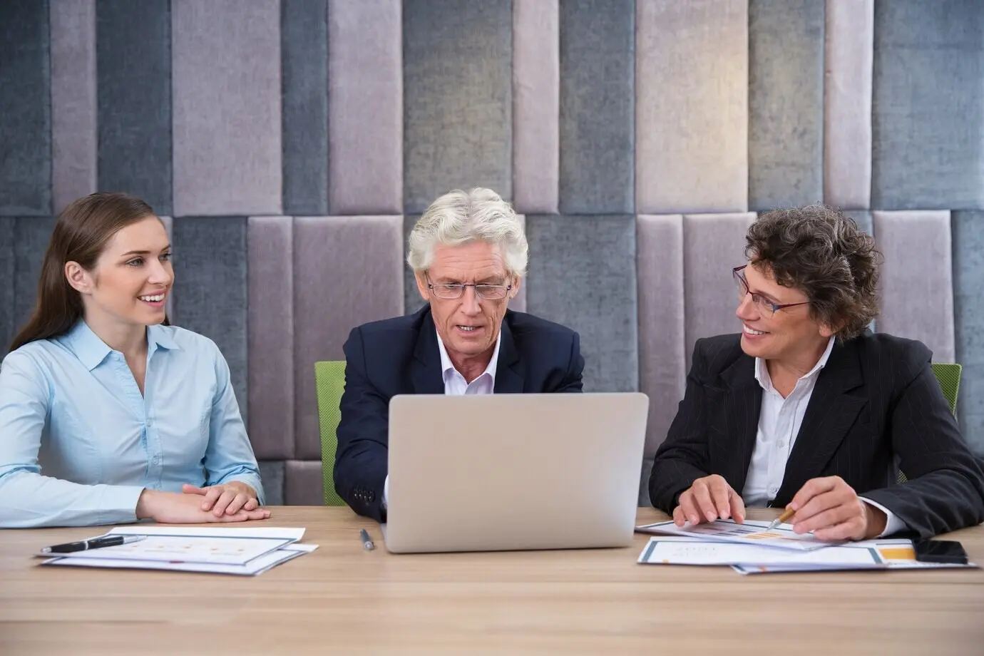 Молодая женщина и мужчина на встрече с ноутбуком.